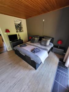 een slaapkamer met 2 bedden en een houten vloer bij villa 2be in Balen