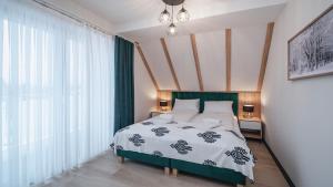 a bedroom with a bed and a large window at Apartamenty Sun & Snow SKI Apartments in Białka Tatrzańska