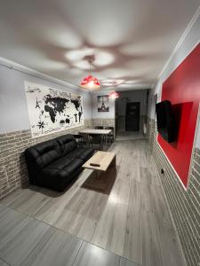 a living room with a black couch and a table at FAMILY apartment in Vinnytsya