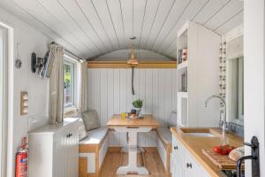 a kitchen with a table in a tiny house at Cherry Blossom, Devon Hideaways in Kenton