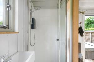 a bathroom with a shower and a white tub at Cherry Blossom, Devon Hideaways in Kenton