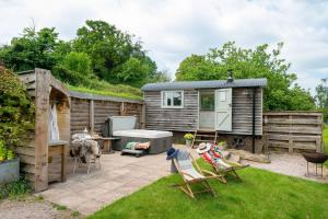 a garden with a tiny house and a patio at Cherry Blossom, Devon Hideaways in Kenton