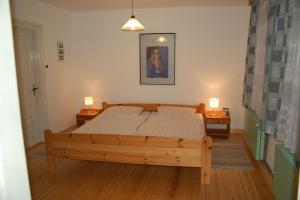 1 dormitorio con 1 cama de madera y 2 mesitas de noche en Alte Stellmacherei Langenhorn, en Langenhorn