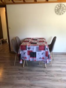 a table with chairs around it with a quilt on it at Hôtel la Kinkerne in Morzine