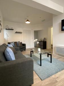 a living room with a couch and a coffee table at Elegant 4 Bedroom, 5 bathroom House in Northampton by HP Accommodation in Watford