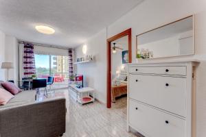 un salon avec un canapé et une chambre dans l'établissement Torres del Sol Beach Front Apartment PH06, à Los Cristianos