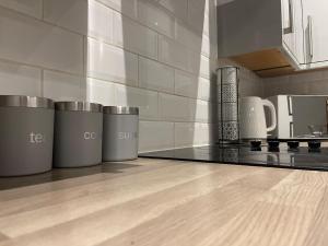 uma cozinha com cinco latas de lixo num balcão em Augustus House 1 Bedroom Apollo Suite em Bradford