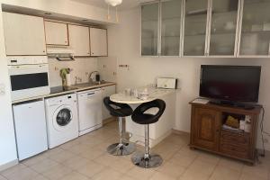 uma cozinha com uma pequena mesa e uma televisão em T2 with balcony close to the sea em Sainte-Maxime