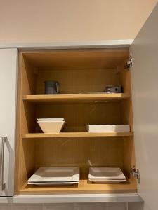 uma cozinha com prateleiras de madeira com pratos e utensílios em Augustus House 1 Bedroom Apollo Suite em Bradford