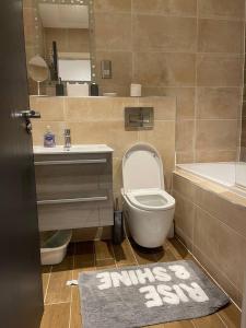 a bathroom with a toilet and a sink and a tub at Augustus House 1 Bedroom Apollo Suite in Bradford