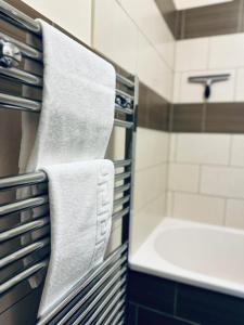 a bathroom with a towel rack with a sink and a tub at Koala & Tree - Cozy and Centric 1 bed apartment - Short Lets & Serviced Accommodation Cambridge in Cambridge