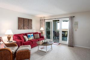 a living room with a red couch and a table at 1317 Pelican Watch Villa in Seabrook Island