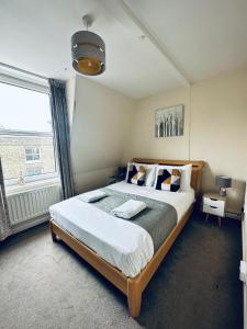 a bedroom with a large bed and a large window at Koala & Tree - Cozy and Centric 1 bed apartment - Short Lets & Serviced Accommodation Cambridge in Cambridge