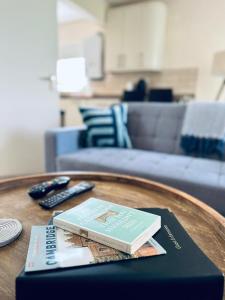 a book on a table with two remote controls at Koala & Tree - Cozy and Centric 1 bed apartment - Short Lets & Serviced Accommodation Cambridge in Cambridge
