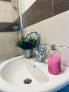 a pink soap bottle sitting on a bathroom sink at Koala & Tree - Cozy and Centric 1 bed apartment - Short Lets & Serviced Accommodation Cambridge in Cambridge