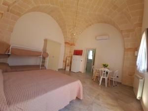 a bedroom with a bed and a table with chairs at Casa Vacanza Fontana in Manduria