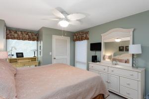 a bedroom with a bed and a dresser with a mirror at 1317 Pelican Watch Villa in Seabrook Island +21 photos