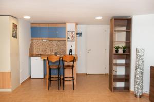 a kitchen with two bar stools and a kitchen with blue cabinets at City Chic Apartments in Limenas