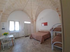 a bedroom with a bed and a table and a table sidx sidx sidx at Casa Vacanza Fontana in Manduria