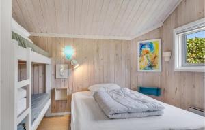 a bedroom with wooden walls and bunk beds and a window at 2 Bedroom Cozy Home In Jerup in Jerup