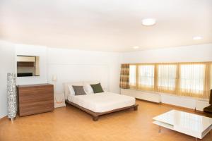 a white bedroom with a bed and a coffee table at City Chic Apartments in Limenas