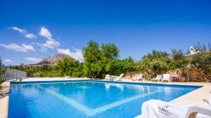 une piscine avec des chaises et une montagne en arrière-plan dans l'établissement Cortijo El Álamo 1 Vélez Blanco by Ruralidays, à Vélez-Blanco