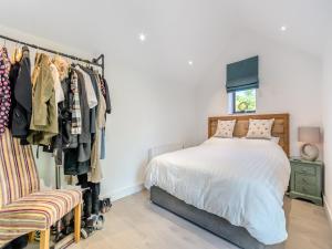 a bedroom with a bed and a rack of clothes at Red Brick Barn - Uk39916 in Howell