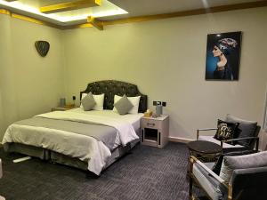 una camera con un grande letto e una sedia di Daraysh Hotel a Sharjah