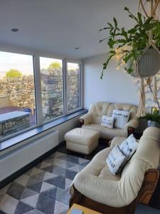 a living room with two couches and a large window at Amazing coastal & sunset views in Eryri (Snowdonia) in Llanllyfni