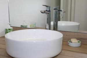 um lavatório branco na casa de banho com um espelho em Dlo Doubout les pieds dans l'eau em Sainte-Anne