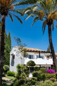 a white house with palm trees in front of it at Golden Mile Designer Penthouse in Marbella