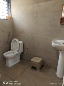 a bathroom with a toilet and a sink at His Grace Holiday Home - Nr to Malpe Beach in Udupi