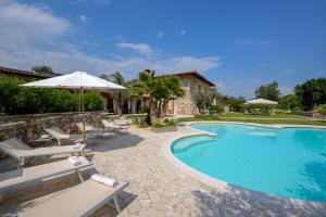 a swimming pool with chairs and an umbrella at Villa Mario Resort in Salò