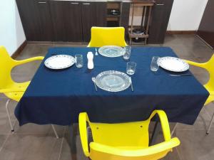 uma mesa de jantar com cadeiras amarelas e uma toalha de mesa azul em La casa de MaCa em Posadas