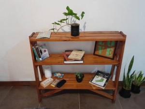 uma estante de livros de madeira com livros e uma planta sobre ele em La casa de MaCa em Posadas