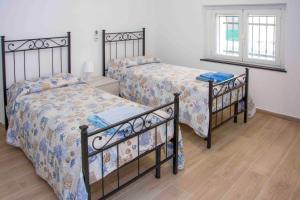 a bedroom with two beds and a window at U Fundu du Cialli in Lavagna