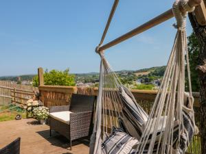 a hammock on a deck with a chair and a view at Dart View Hideout in Totnes