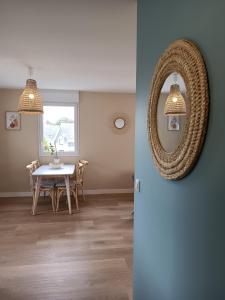 - une salle à manger avec une table et un miroir dans l'établissement Appartement Détente au Cœur du Cotentin, à Valognes