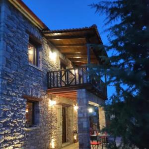 un edificio de piedra con un balcón en un lateral. en Kleitor Stone Villa-Peloponnese Getaway en Klitoria