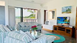 a living room with two couches and a tv at Beach Penthouse BELMARE in Belle Mare