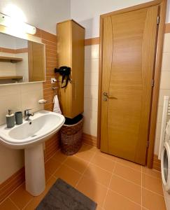 a bathroom with a sink and a wooden door at Mylos Ηome in Ierápetra