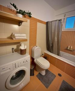 a bathroom with a washing machine and a toilet at Mylos Ηome in Ierápetra