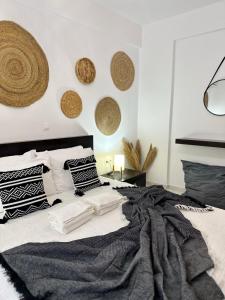 um quarto com uma cama preta e branca com almofadas em Mylos Ηome em Ierápetra