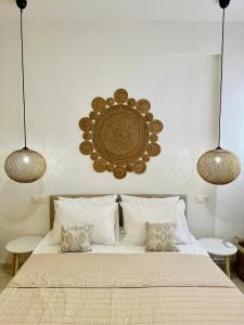 a bedroom with a bed with two lights above it at Mylos Ηome in Ierápetra