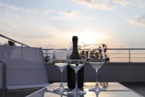 una bottiglia di vino e due bicchieri sul balcone di SUNSEA - Enjoy Your Family a Capo Vaticano