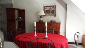 Saint-Martin-le-BeauにあるAppartement De La Valléeの赤いテーブルクロスと三本のろうそくを持つテーブル