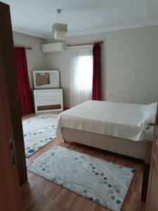 1 dormitorio con cama y alfombra en el suelo en Nergis dağ evi, en Trabzon
