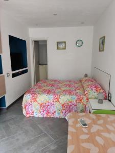 a bedroom with two beds and a flat screen tv at Arco Bianco - Monolocali in Tortolì