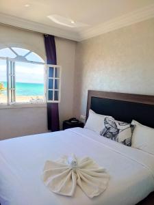 a bedroom with a bed with a flower on it at AMWAJ HOTEL in El Jadida