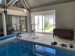 ein Haus mit einem Pool in einem Zimmer in der Unterkunft Villa Fontaine avec piscine intérieur chauffée in Fontaine-la-Gaillarde
